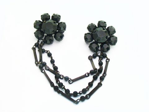Strass Brosche in Schwarz - Blume mit Kette - Gefasst, Hersteller: Juwelier Harnisch, elegante schwarze Blütenform mit feiner Kette kombiniert, ideal für stilvolle Akzente.