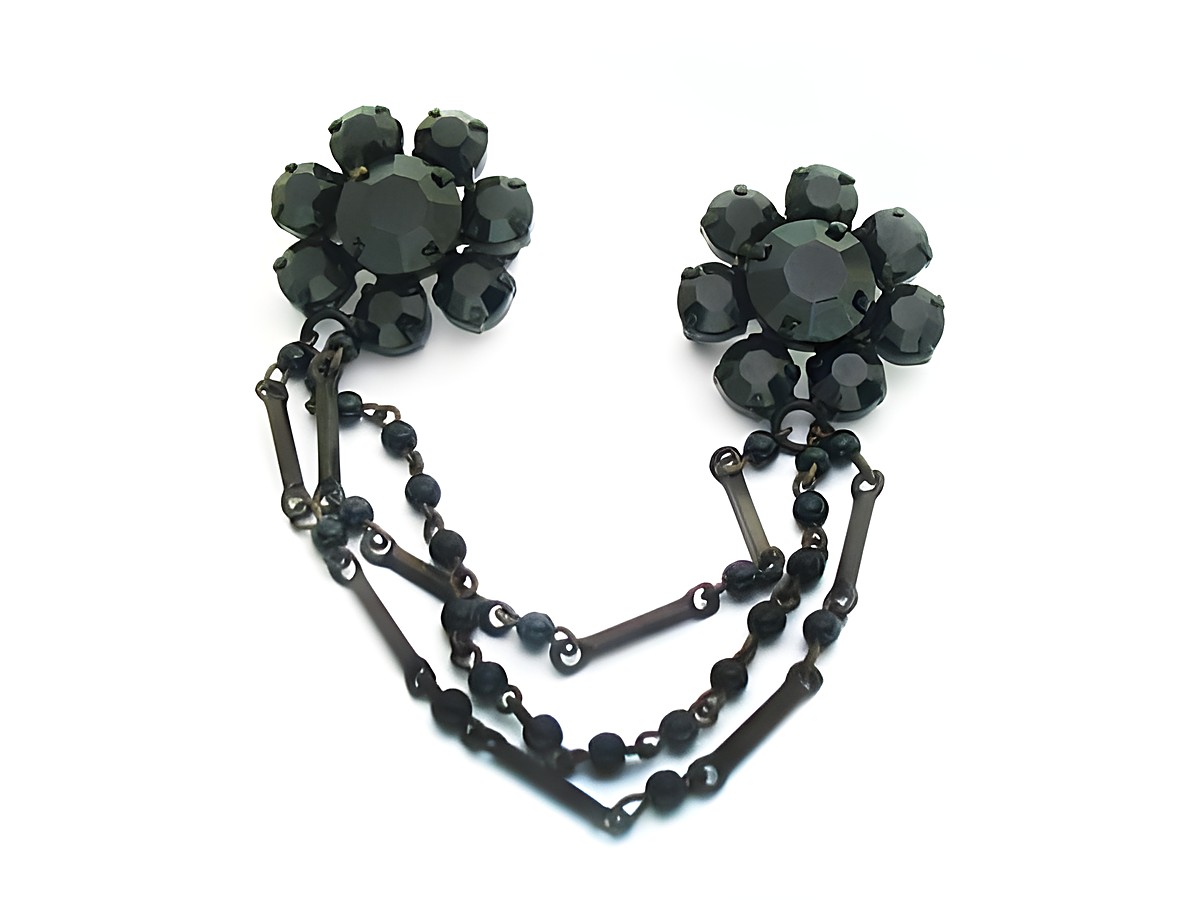 Strass Brosche in Schwarz - Blume mit Kette - Gefasst, Hersteller: Juwelier Harnisch, elegante schwarze Blütenform mit feiner Kette kombiniert, ideal für stilvolle Akzente.