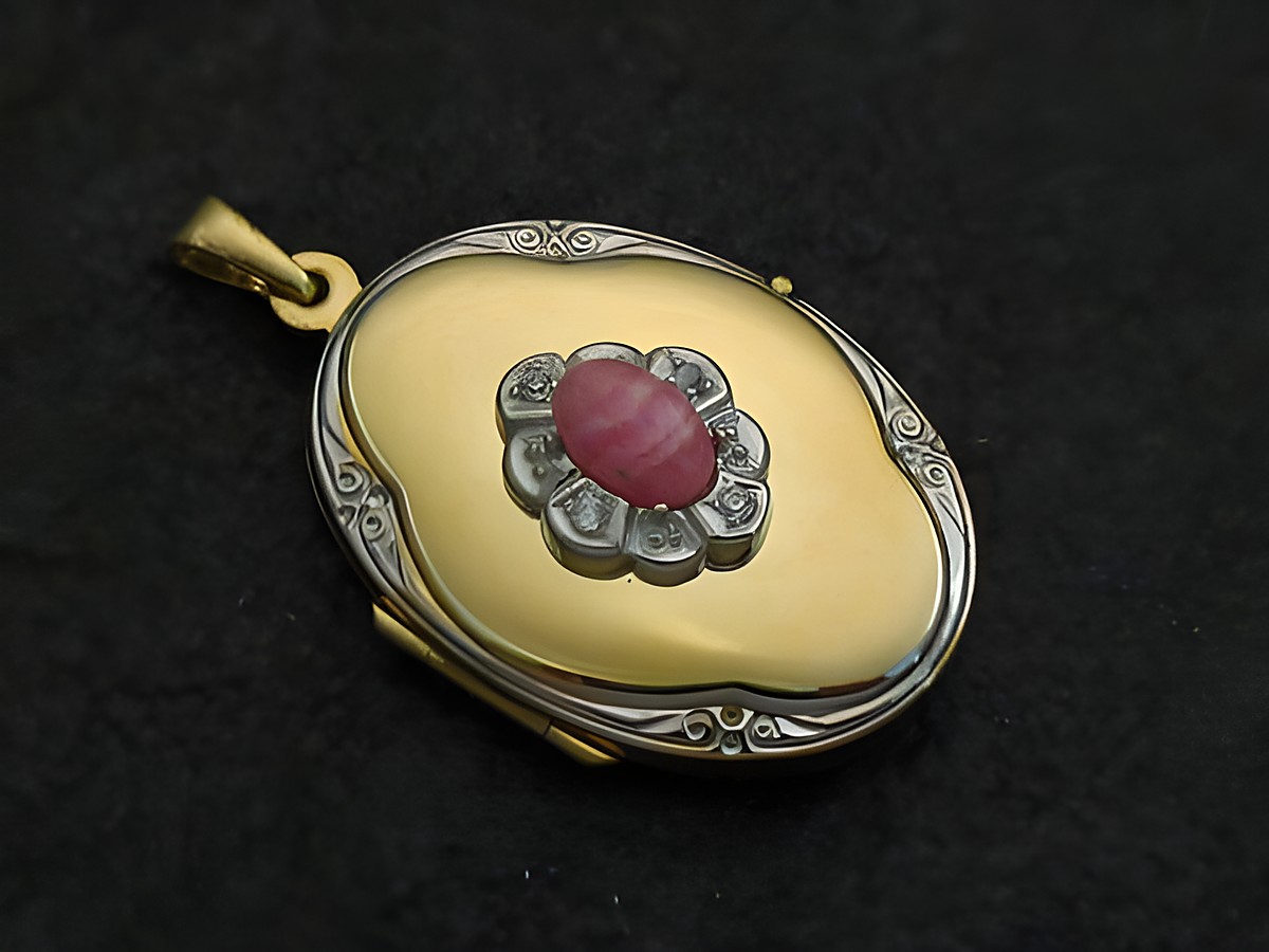 Rhodochrosit Medaillon Cabochon in Gold 585 bicolor, verziert mit einem eleganten Muster und einem zentralen rot-rosa Stein, hergestellt von Juwelier Harnisch.