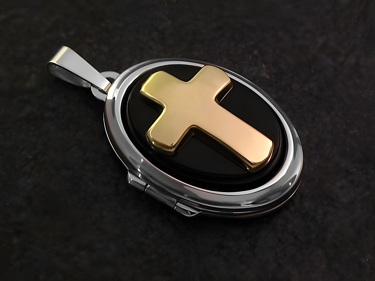 Ein weißgoldenes Medaillon mit einem schwarzen Cabochon und einem goldenem Kreuz darauf. Der Anhänger hat eine charmante ovalen Form und edle Materialien, hergestellt von Juwelier Harnisch.