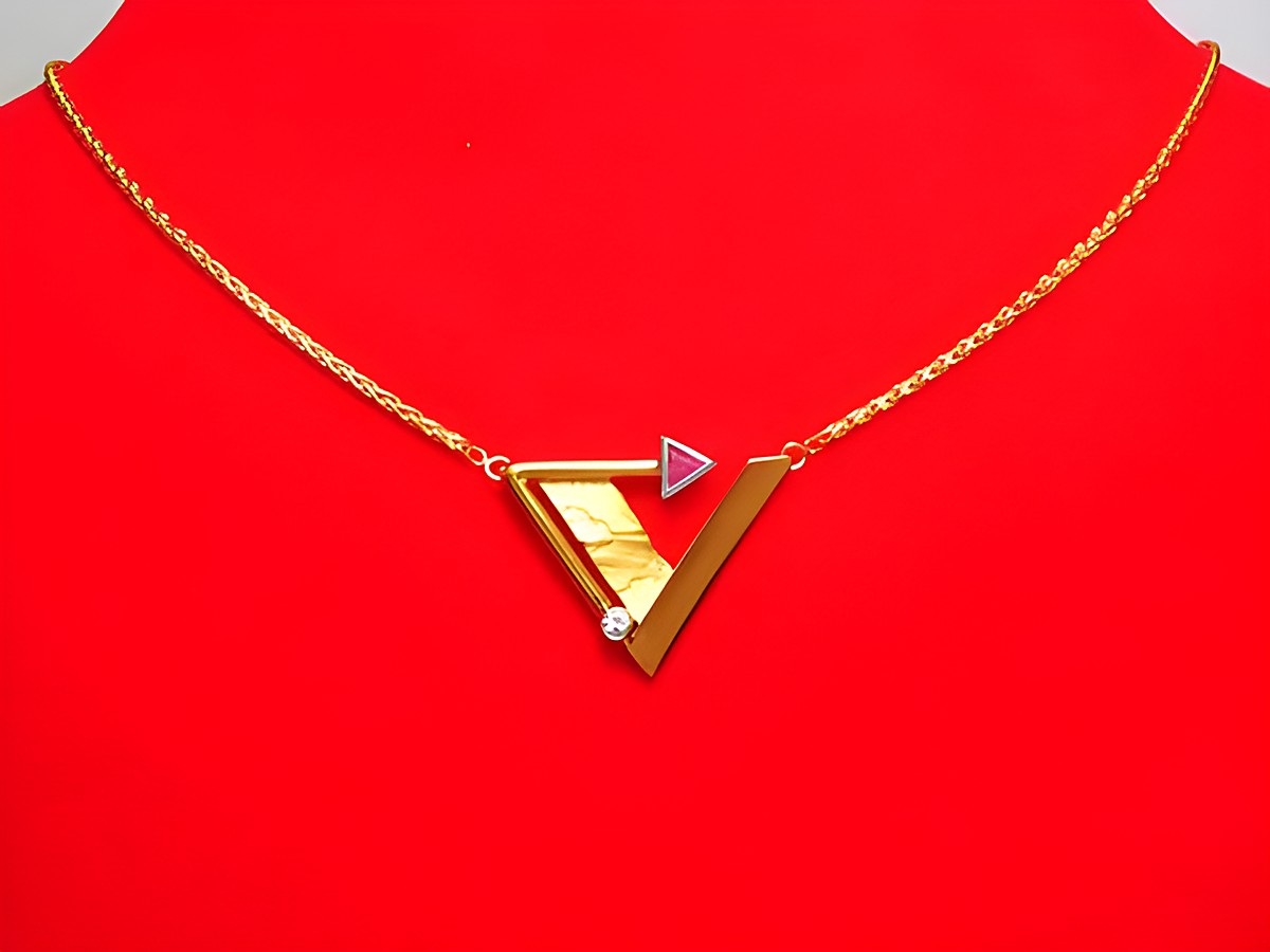 Collier aus Gold 333 mit einem auffälligen Mittelteil aus Rubin und Zirkonia, Länge 45 cm, gefertigt von Juwelier Harnisch, stilvolles Design auf rotem Hintergrund.