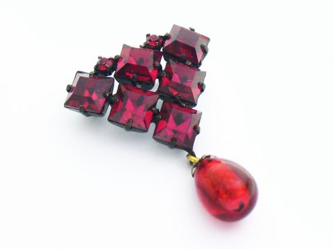 Rote Strass Designer Brosche im sexy City Look mit quadratischen roten Steinen und einer tropfenförmigen roten Verzierung, Hersteller Juwelier Harnisch.