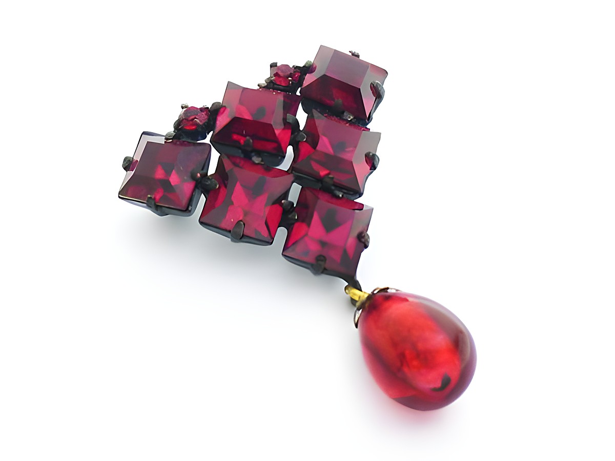 Rote Strass Designer Brosche im sexy City Look mit quadratischen roten Steinen und einer tropfenförmigen roten Verzierung, Hersteller Juwelier Harnisch.