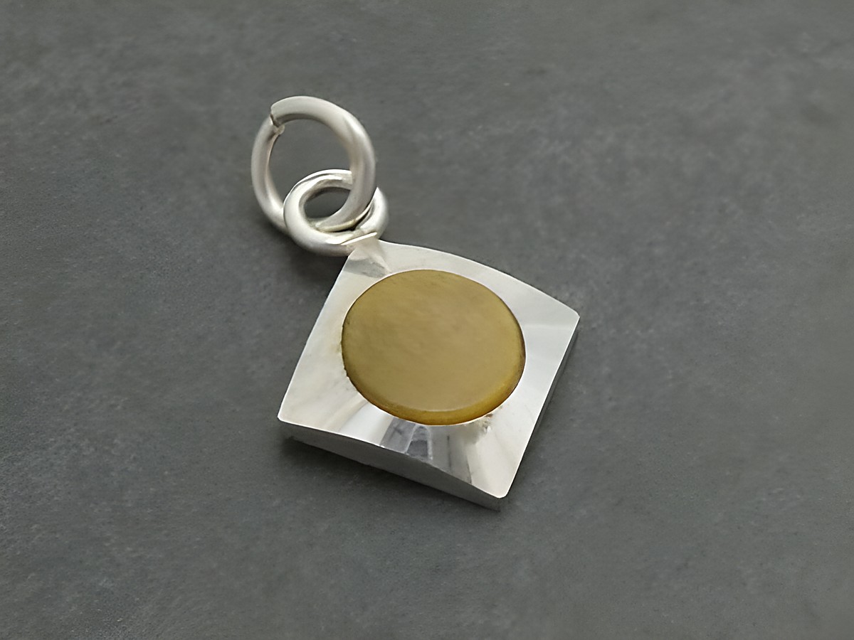 Silber Anhänger mit rhodiniertem Finish und rundem Tigerauge, Hersteller Juwelier Harnisch, schlichtes und elegantes Design, ideal als Schmuckstück oder Geschenk.