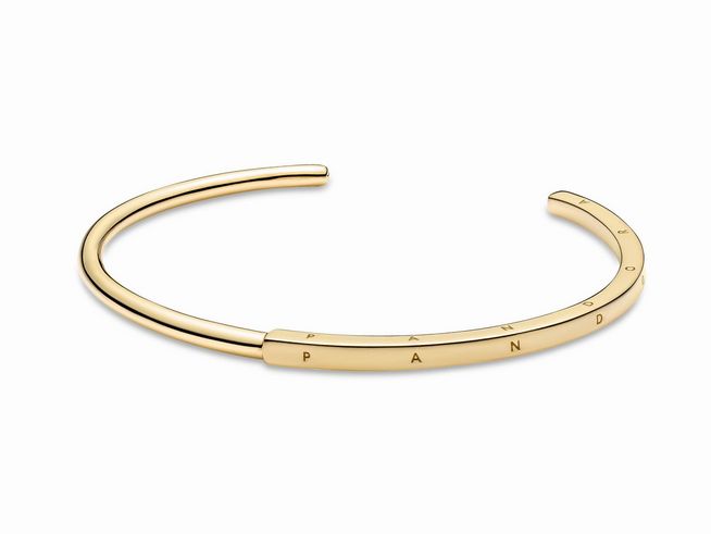 Ein eleganter, goldfarbener Pandora Signature I-D Armreif mit einer Länge von 20,50 cm, der zeitloses Design und hochwertige Verarbeitung vereint.