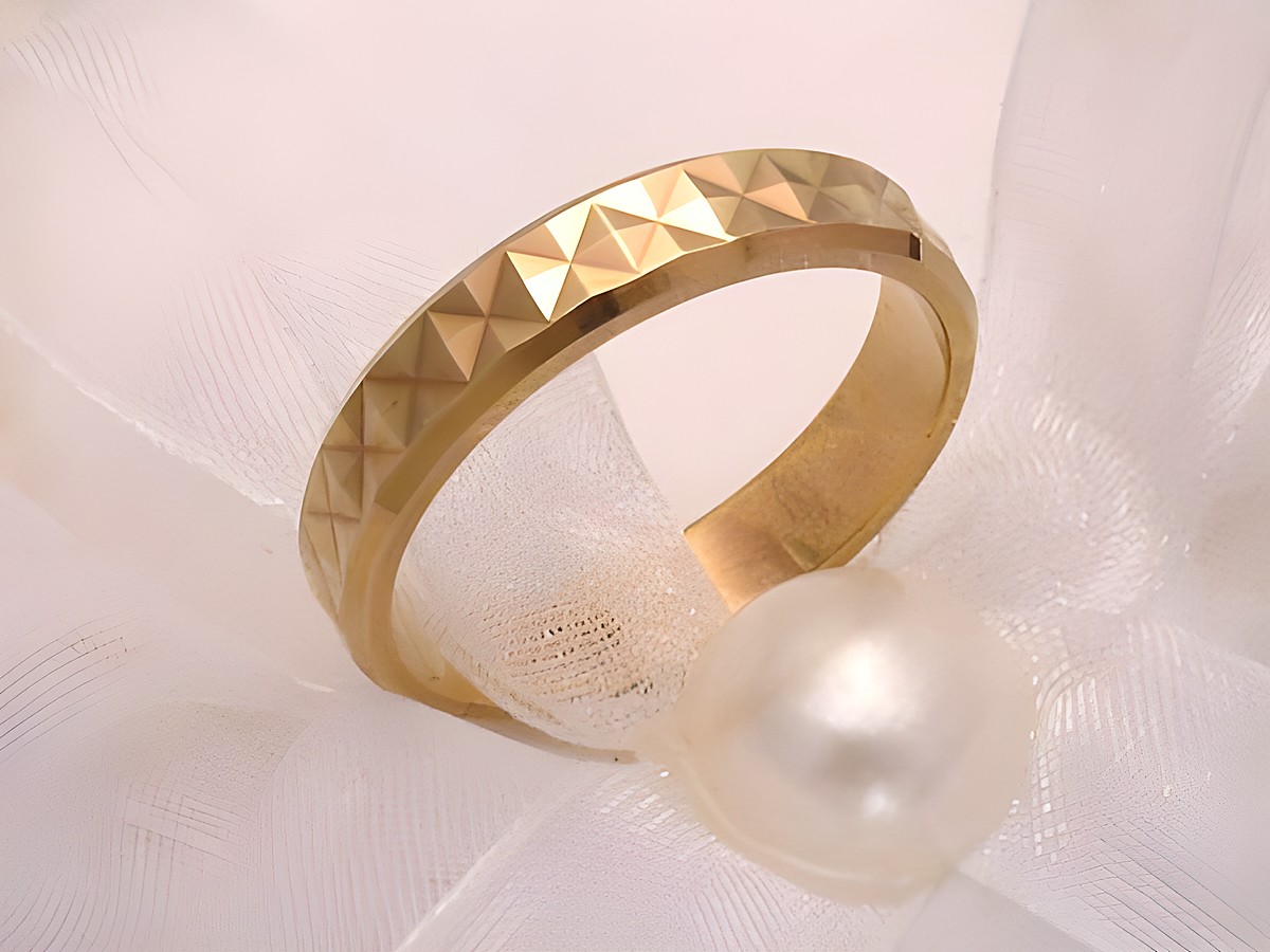 Trauring Ehering MAGICALLY in Gold 333, Größe 55/17,5, Hersteller Juwelier Harnisch, bis Größe 56/17,8, auf einem weichen, weißen Untergrund mit einer Perle dekoriert.