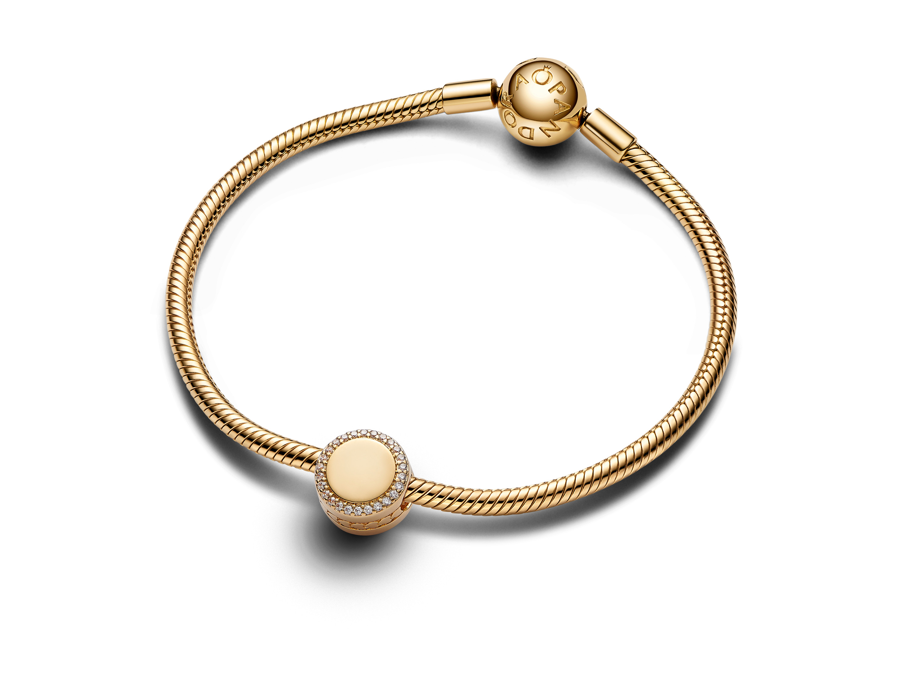 Funkelnder Pandora Charm in Gelbgold, verziert mit Zirkonia, präsentiert auf einem eleganten Armband mit graviertem Verschluss, ideal für persönlichen Schmuckstil.