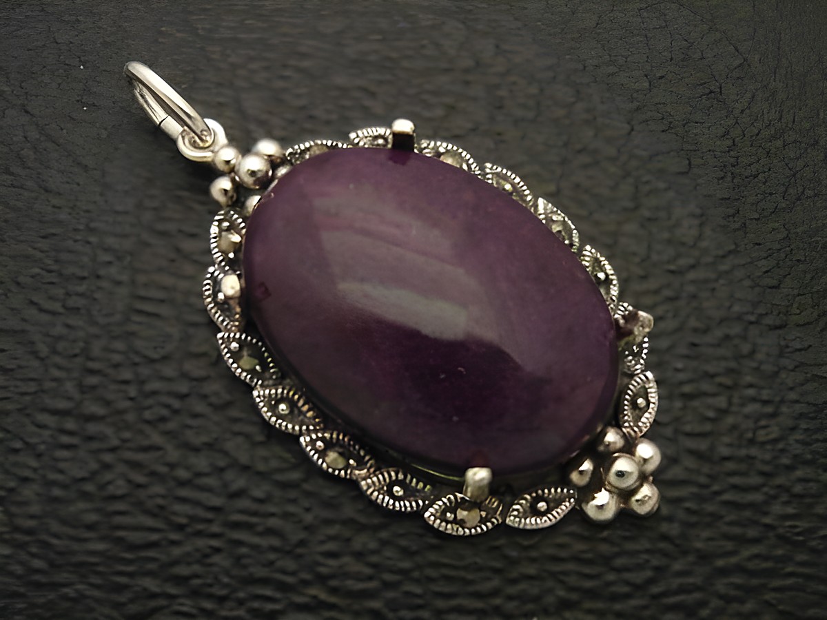 Cabochon Jade in violett gefasst in einem filigranen Silber Medaillon Anhänger, Hersteller Juwelier Harnisch, elegantes Design mit besonderen Details.