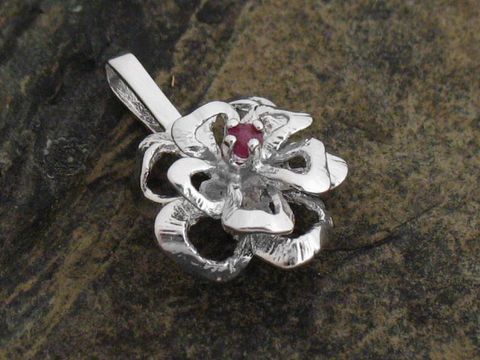 Silber Anhänger in Blumenform mit einem roten Rubin, gefertigt aus echtem rhodiniertem Silber, Hersteller Juwelier Harnisch. Elegantes und filigranes Design für individuellen Schmuck.