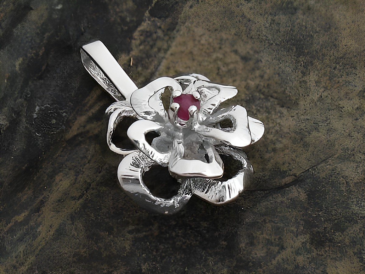 Silber Anhänger in Blumenform mit einem roten Rubin, gefertigt aus echtem rhodiniertem Silber, Hersteller Juwelier Harnisch. Elegantes und filigranes Design für individuellen Schmuck.