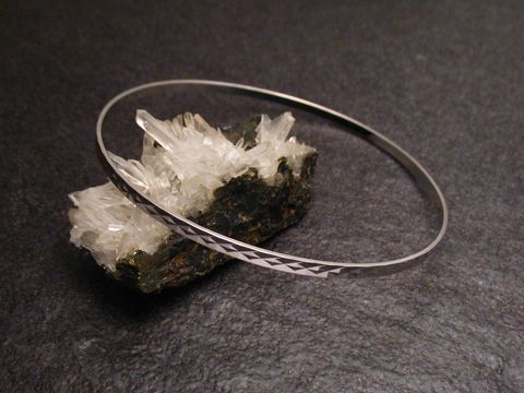 Armreifen fein - 2,5 mm - Weißgold 585 - 22 cm, Hersteller: Juwelier Harnisch, Armreifen auf einem dunklen Untergrund mit Kristallstücken im Hintergrund.
