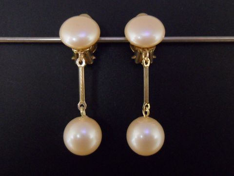 71800-0 Ohrclip in hellrosa mit zeitlosem Design und goldfarbener Fassung, ergänzt durch eine synthetische Zuchtperle, hergestellt von Juwelier Harnisch.