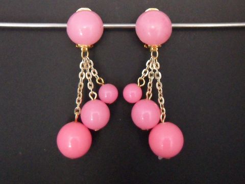 71898-0 Ohrclip in rosa zeitlos mit goldfarbenen Akzenten und Kunstharzkugeln, hergestellt von Juwelier Harnisch, präsentiert ein auffälliges Design mit hängenden Elementen.