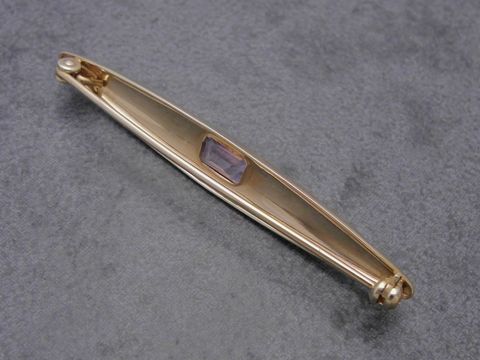 Eine edle Gold Brosche aus Gold 333 mit einem Amethyst als Zierelement, Hersteller: Juwelier Harnisch, ideal als Anstecknadel für besondere Anlässe.