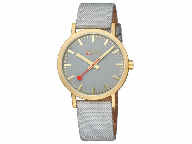 Mondaine Classic Uhr A660.30360.80SBU mit 40 mm Gehäuse in IP Gelbgoldvergoldung und grauem Zifferblatt, samt grauem Textilarmband und roter Sekundenzeiger.
