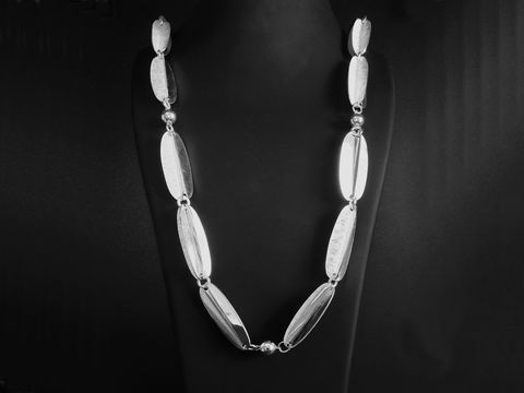 Design Collier mit ovalen Elementen in versilberter Ausführung. Die Kette hat eine Länge von 88 cm und ist elegantes Schmuckstück für stilvolle Akzente. Hersteller ist Juwelier Harnisch.