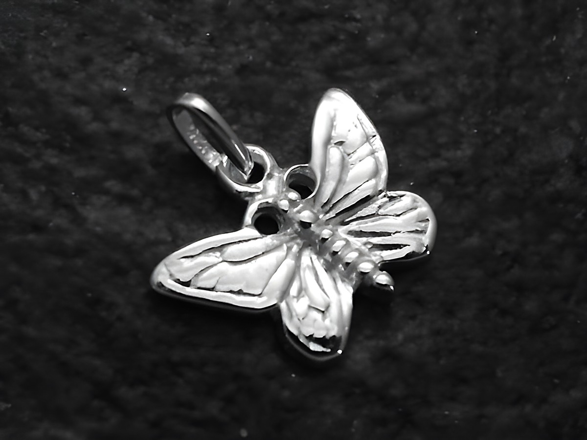Zierlicher Schmetterling Anhänger aus Sterling Silber, hergestellt von Juwelier Harnisch, ideal für Kinder, zeigt detaillierte Flügelstruktur und einen glänzenden Oberflächenfinish.