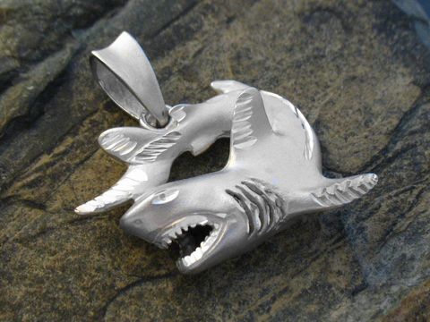 Ein detaillierter Anhänger aus 925 Sterling Silber in Form von zwei angreifenden Haien, hergestellt von Juwelier Harnisch, ideal für Tierliebhaber und Hai-Fans.