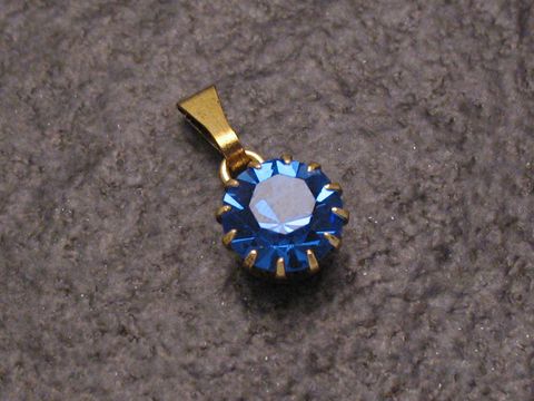 Blauer Strass Anhänger mit rundem Design, verziert mit funkelnden glitzernden Facetten, in goldfarbener Fassung, ideal für einen sexy Stadtlook, Hersteller: Juwelier Harnisch, auch in weiteren Formen erhältlich.
