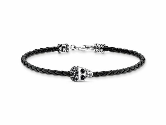 56970736-0 Ein geflochtenes Lederarmband in Schwarz mit einem geschwungenen Totenkopf aus Sterling Silber und Zirkonia, ideal für stilvolle Akzente. Länge von 17,5 cm.