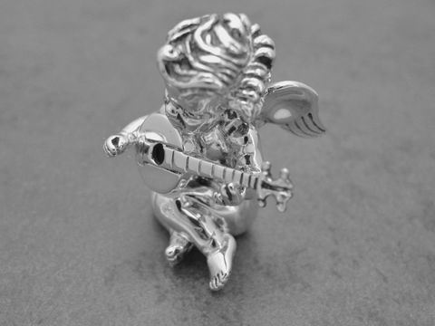 Eine plastisch gestaltete Silberfigur eines Schutzengels, der auf einem Podest sitzt und eine Laute spielt. Die Figur ist rhodiniert und wirkt elegant und detailreich. Herstellungsinformationen: Juwelier Harnisch.