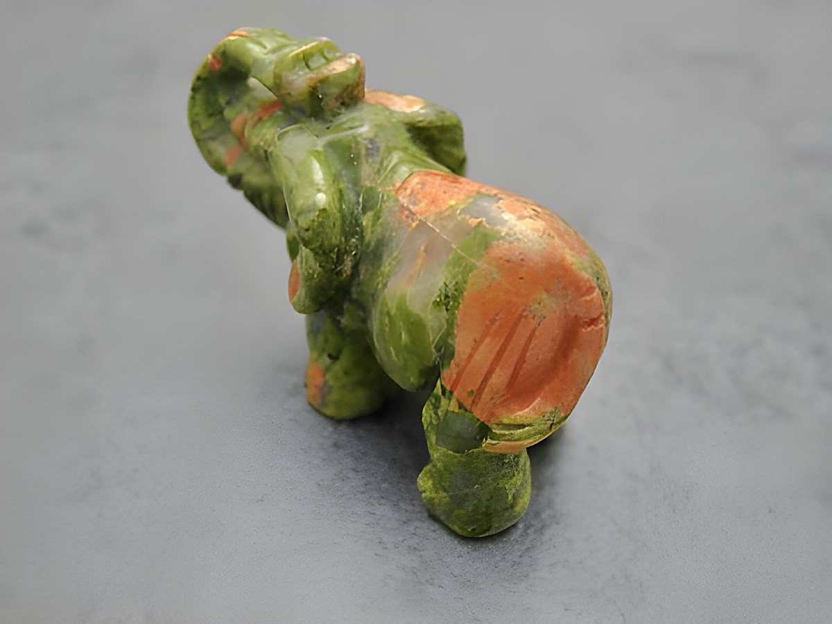 Plastische Steinfigur eines Elefanten aus grün-braunem Achat, stehend, als Glücksbringer gestaltet. Hersteller: Juwelier Harnisch, Steinfiguren. – Ansicht 2