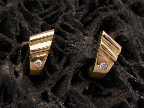 Moderne goldene Ohrringe mit Zirkonia, hergestellt von Juwelier Harnisch, zeichnen sich durch ein elegantes Design und glitzernde Steine aus. Ideal für einen stilvollen Auftritt.