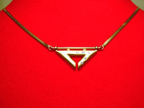 Collier Goldkette 585 Mittelteil mit Zirkonia in geometrischer Form, 45 cm lang, präsentiert auf rotem Untergrund, Hersteller Juwelier Harnisch.