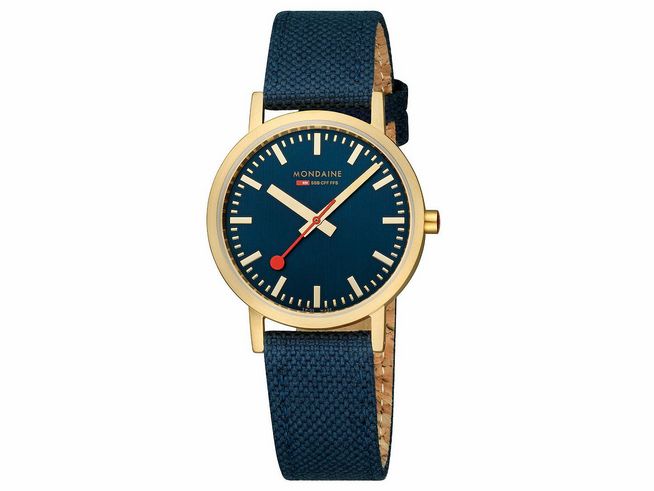 Mondaine Classic Uhr A660.30314.40SBQ mit 36 mm Gehäuse in IP Gelbgoldvergoldung und oceanblauem Ziffernblatt. Das Armband ist aus textilem Material in Dunkelblau.