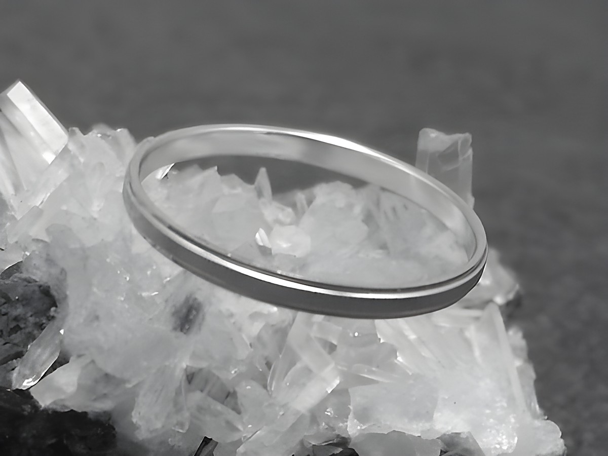 Silber Ring rhodiniert 2mm breit in Größe 50 15,8mm von Juwelier Harnisch, elegant auf kristallinem Untergrund präsentiert. Der Ring eignet sich für den täglichen Gebrauch.