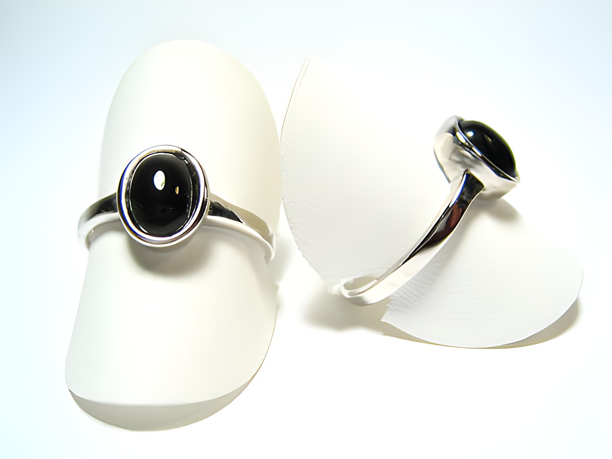 Feiner Designer Silber Ring rhodiniert mit schwarzem Onyx, Hersteller Juwelier Harnisch, Ringe verstellbar, elegant auf weißen Ringständern präsentiert.