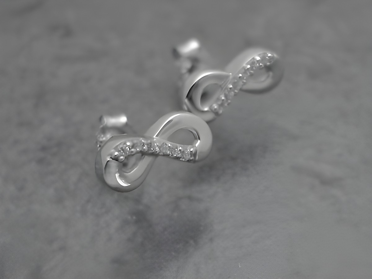 Ohrringe mit Unendlich Symbol aus rhodiniertem Sterling Silber, verziert mit Zirkonia in Weiß, symbolisch und elegant, hergestellt von Juwelier Harnisch.