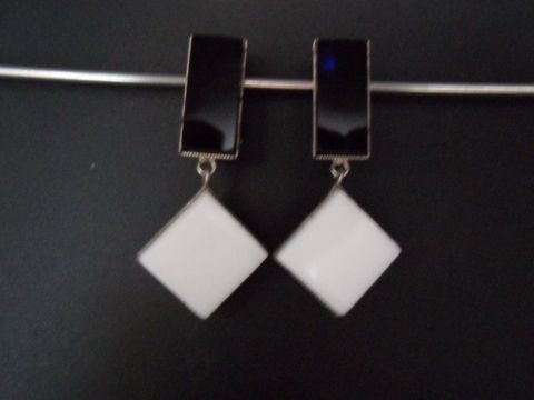 Schwarze und weiße Ohrclips aus Kunstharz mit silberfarbenen Elementen, zeitloses Design, Hersteller Juwelier Harnisch, elegantes Accessoire für besondere Anlässe.