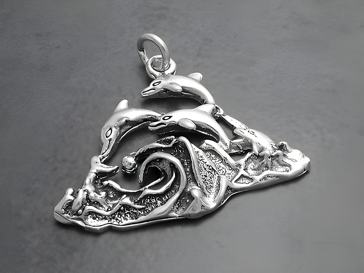 Drei Delfine springen über stilisierte Wellen, gefertigt aus Silber, als Anhänger im Tümmler-Design von Juwelier Harnisch, ideal für Tierliebhaber.