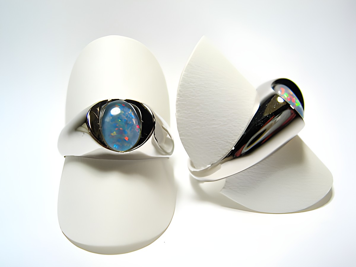Designer Silber Ring rhodiniert mit buntem Opal Triplette, vielseitig und verstellbar, hergestellt von Juwelier Harnisch, elegant präsentiert auf einem weißen Ringständer.