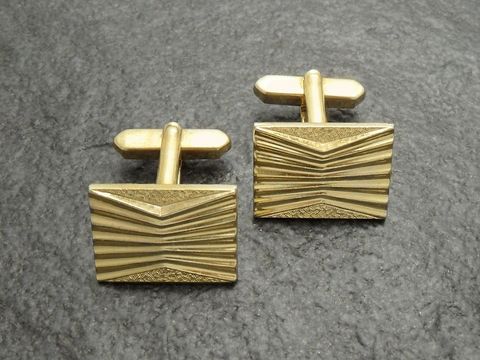 Vergoldete Manschettenknöpfe mit einem modernen Design, rechteckige Form und Rillenmuster, hergestellt von Juwelier Harnisch, goldfarben. Ideal für elegante Anlässe.