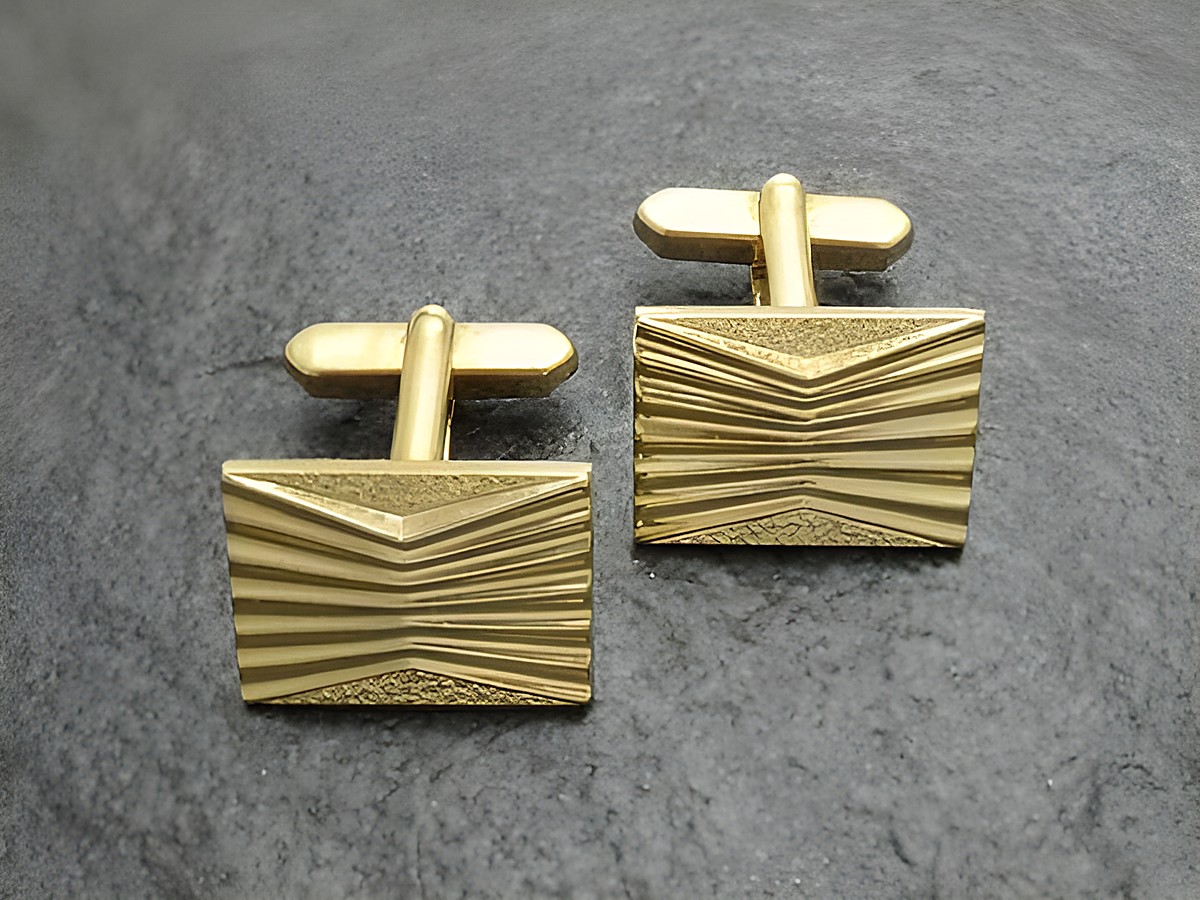 Vergoldete Manschettenknöpfe mit einem modernen Design, rechteckige Form und Rillenmuster, hergestellt von Juwelier Harnisch, goldfarben. Ideal für elegante Anlässe.