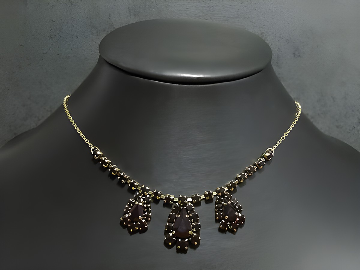 Elegante goldfarbene Halskette mit granatroten Anhängern, individuelle Länge von 42,5 bis 46,5 cm, von Juwelier Harnisch, ansprechende Fassung in Gold.