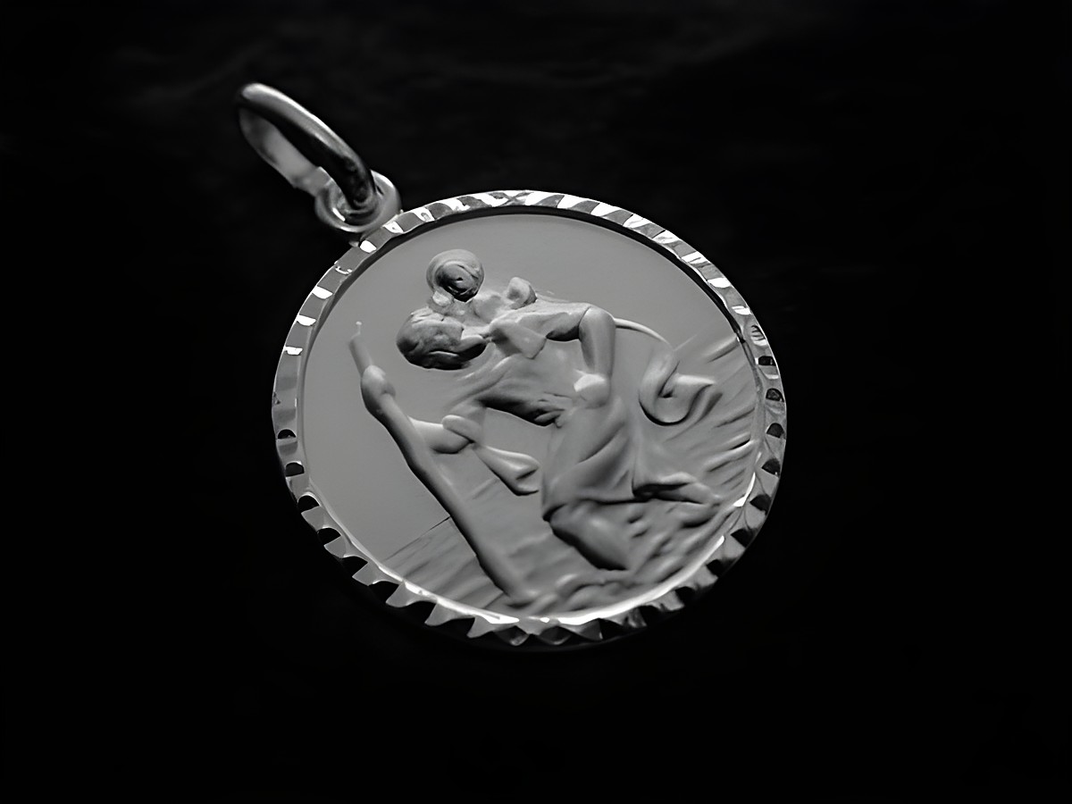 Ein Christophorus Anhänger aus 925 Silber mit rhodiniertem Finish. Das Relief zeigt den Schutzpatron Christophorus, der einen Pilger über einen Wasserlauf trägt.