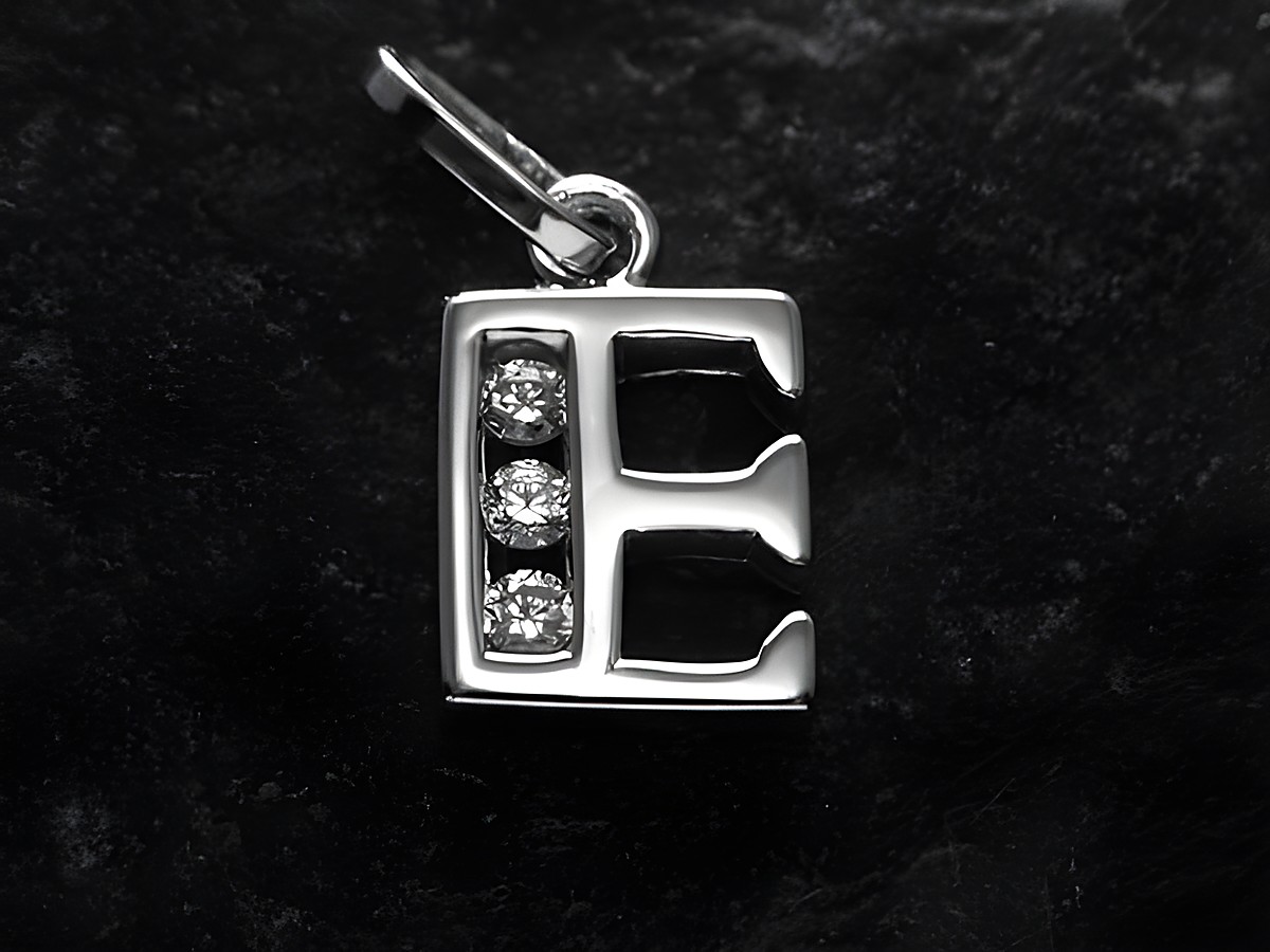 Silber rhodinierten Anhänger in Form des Buchstabens E, versehen mit drei funkelnden Zirkoniasteinen, hergestellt von Juwelier Harnisch. Ideal für individuelles Schmuckdesign.