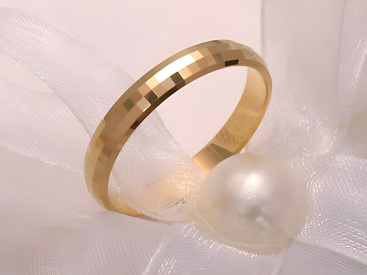 Ehering aus 585er Gold in Größe 64 mit funkelndem Design, sanft geschwungene Form und polierte Oberfläche, präsentiert auf hellem Untergrund zusammen mit einer Perlenschnur.