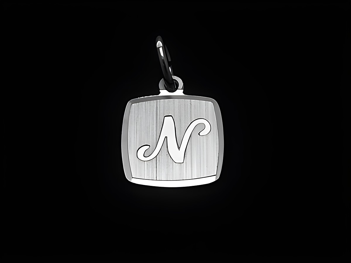 Buchstabe N Anhänger aus rhodiniertem und mattiertem Sterlingsilber, der auf einer schwarzen Unterlage präsentiert wird. Hersteller ist Juwelier Harnisch.