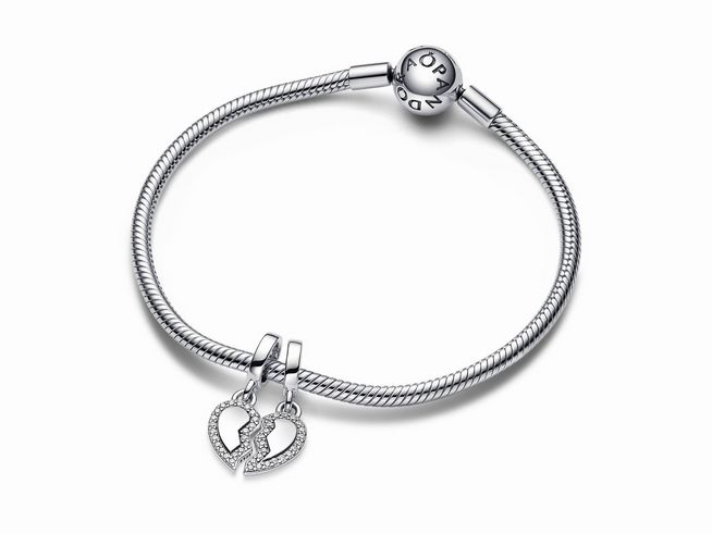 Sterling Silber Charm-Anhänger von Pandora mit einem Teilbaren Herz Design, verziert mit Zirkonia, hängt an einem feinen Armband, ideal für Freundschafts- oder Liebesgeschenke.