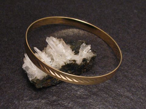 Gold Armreifen charmant - 6,4 mm - echt Gold - 21 cm auf einem mineralischen Untergrund, elegant und zeitlos, hergestellt von Juwelier Harnisch.