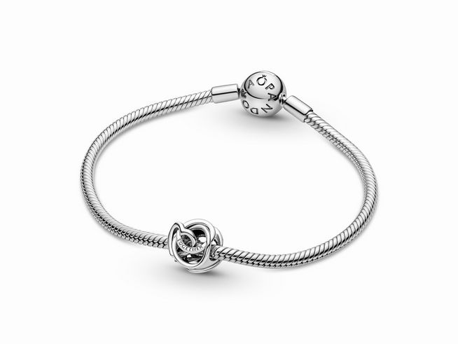 Ein elegantes Armband aus Sterling Silber von Pandora mit einem verschlungenen Herz Charm, das für die Familie steht, perfekt als Geschenk oder persönlicher Schmuck.
