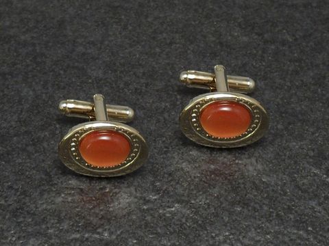 Manschettenknöpfe in orange mit einem Durchmesser von 18,9 mm, goldfarbene Fassung, Hersteller Juwelier Harnisch, ideal für elegante Anlässe.