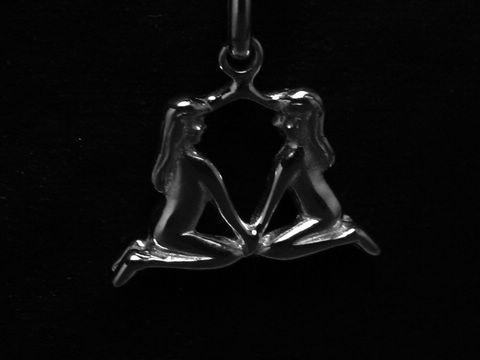 Zwei neugierige Zwillingsfiguren, die sich gegenüber sitzen und Hände halten, aus rhodiniertem 925 Sterling Silber, von Juwelier Harnisch, für das Sternzeichen Zwillinge.