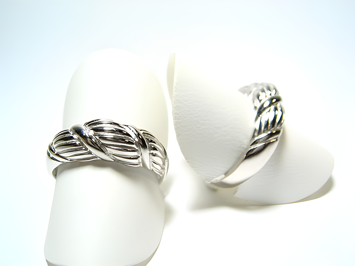 Silber Ring rhodiniert -gewölbt & rundlich- verstellbar, Hersteller: Juwelier Harnisch, ohne Stein, präsentiert auf einem weißen Ringhalter in einem modernen Design.