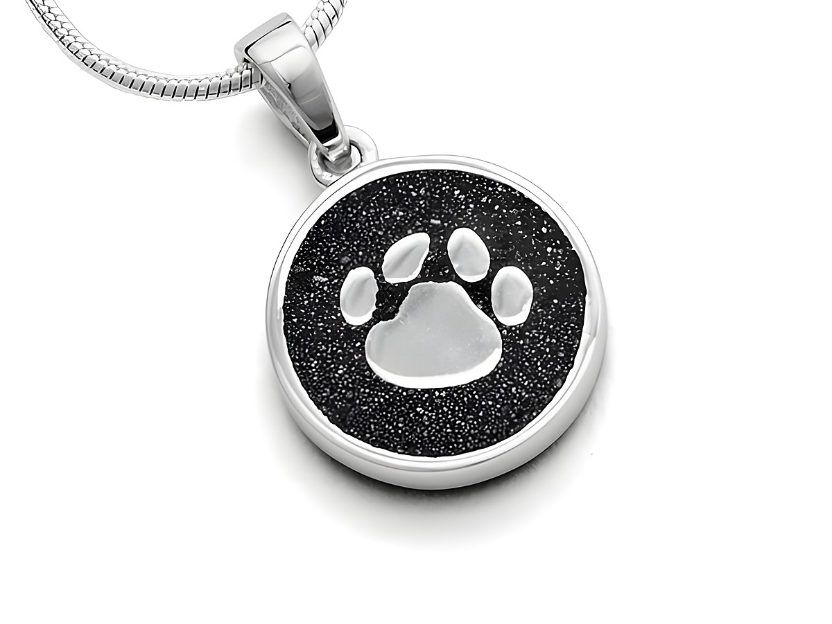 Sterling Silber Anhänger mit einem Pfotenabdruck auf schwarzem Lavasand, ideal als Glücksbringer, von DUR Schmuck Modell P2940.