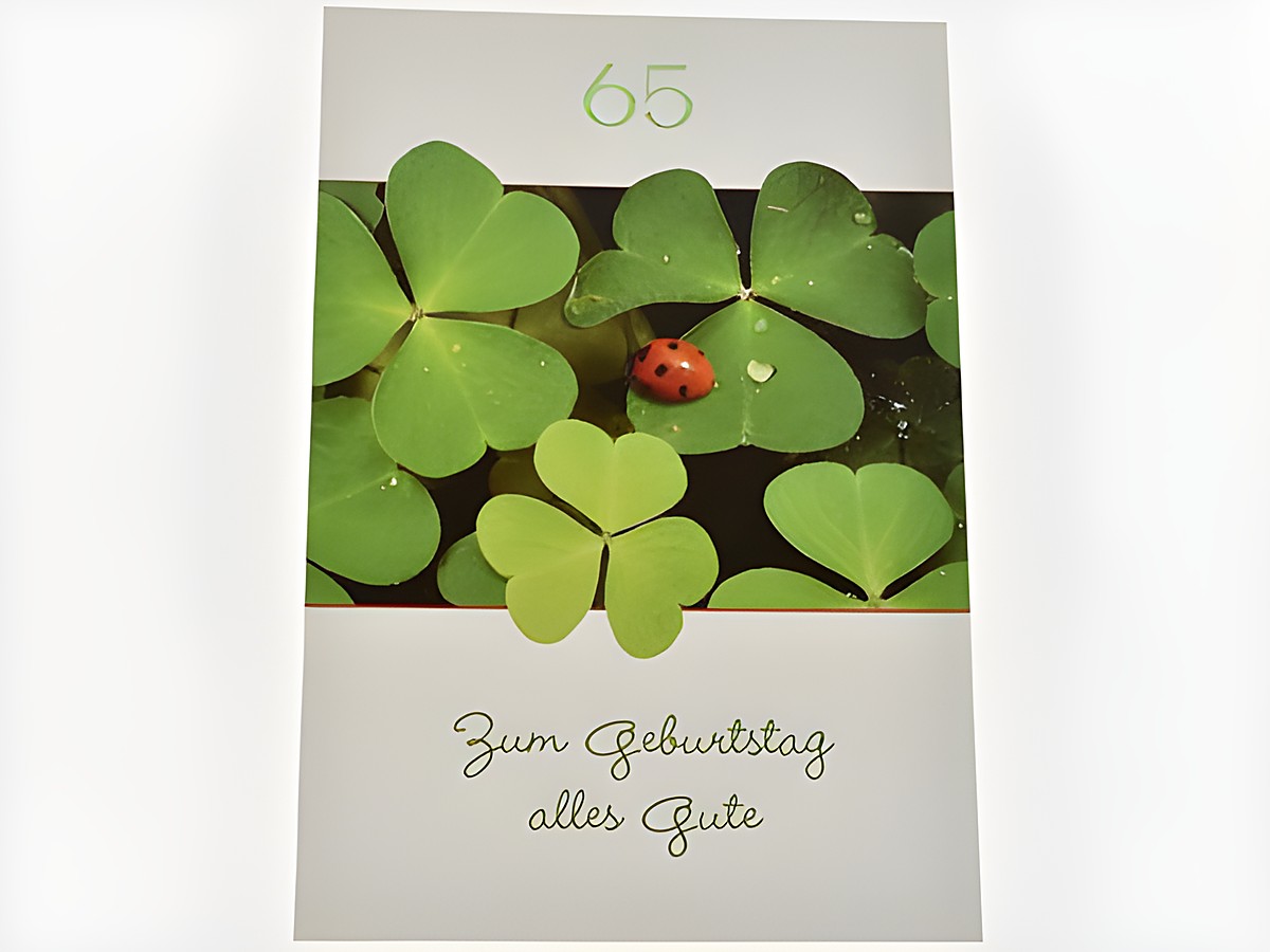 Geburtstagskarte mit Glücksklee und einem Marienkäfer, verdeutlicht mit der Aufschrift "Zum Geburtstag alles Gute" und der Zahl 65, hergestellt von Juwelier Harnisch.
